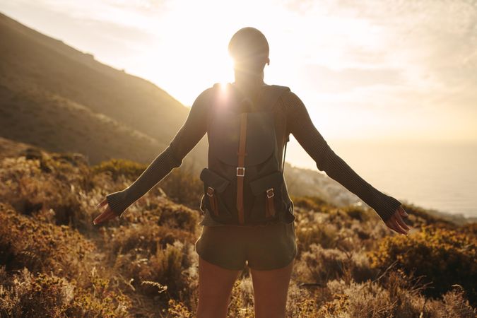 Female hiker embracing the sun light on top of mountain