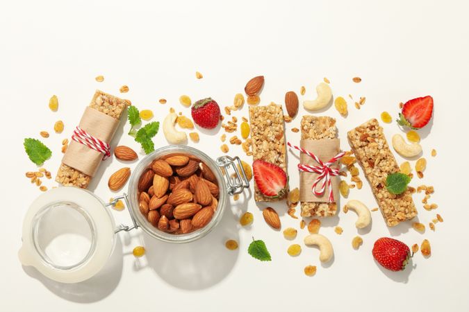 Granola bars, strawberry and almond on blank background, top view