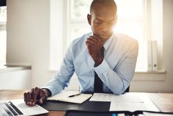 Serious man in suit and tie working at his desk