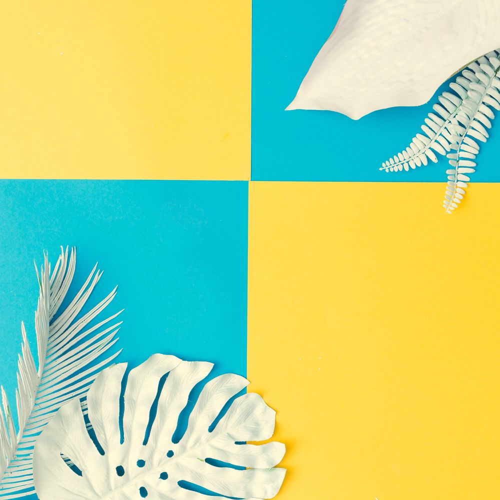 Painted tropical and palm leaves on cyan and yellow background