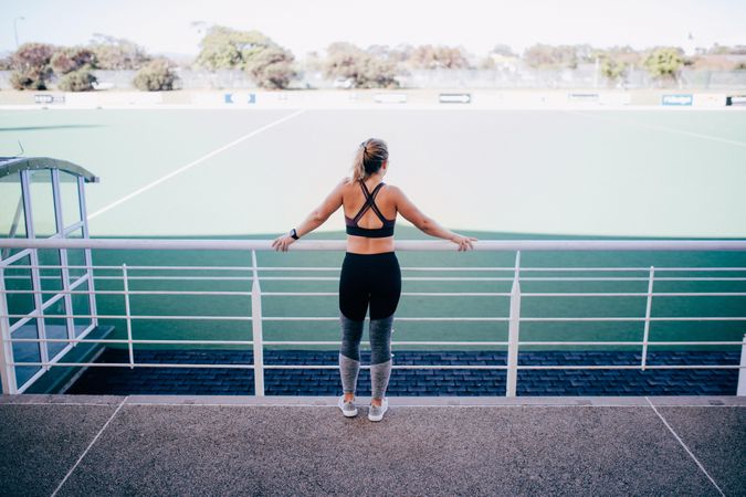 Woman in activewear overlooking a sports field