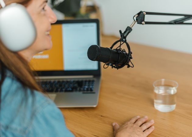 Woman recording podcast at table with mic