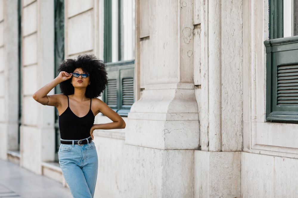 Cheerful Black female in dark sunglasses