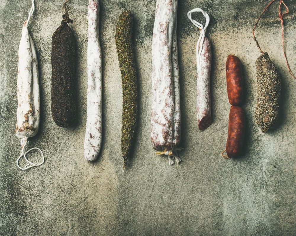 Variety of cured meat sausages displayed in a row