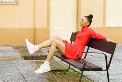 Female sitting on outdoor seat kicking legs