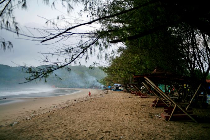 Foggy beach in Indonesia with people walking in distance