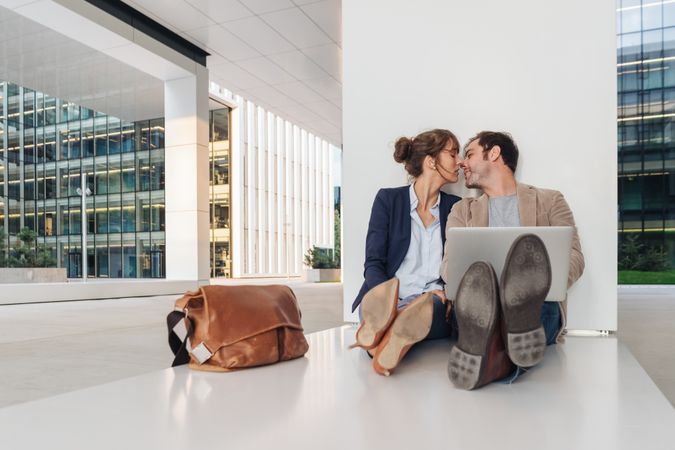 Entrepreneur couple using laptop on street