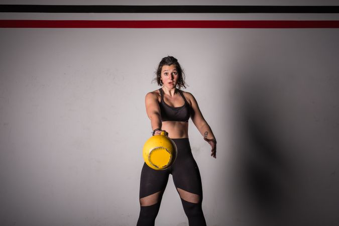 woman lifting kettlebell in gym