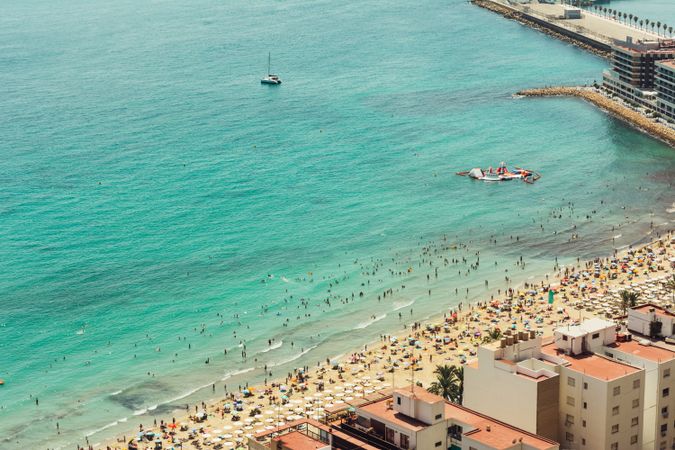 Stunning turquoise water and seashore with people palms boats
