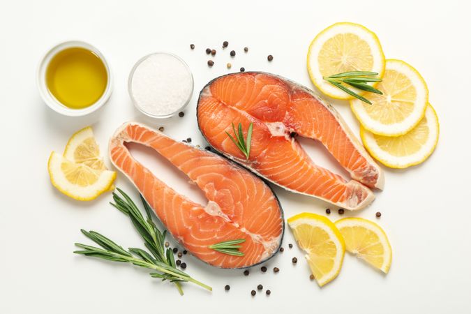 Composition with salmon meat and spices on plain background, top view