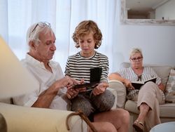 Boy with grandfather surfing tablet together