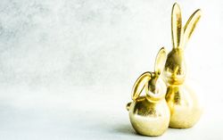 Easter holiday card concept with two golden rabbit figurines