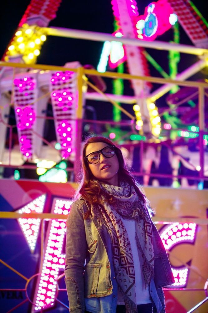 Stylish young woman near illumination on street
