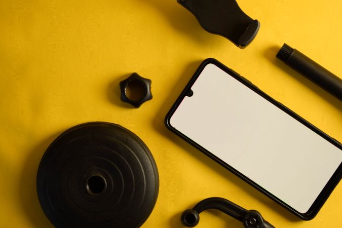 Mock up phone with accessories scattered on yellow background