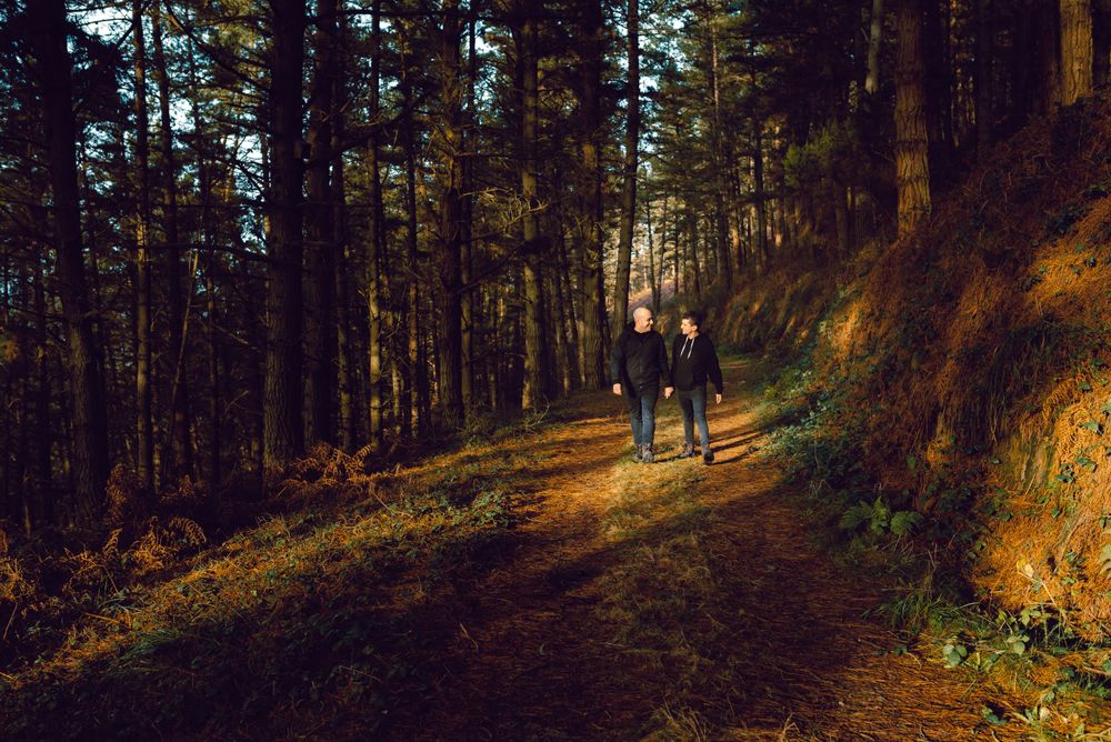 Men holding hands and walking in forest