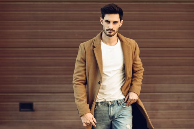 Man in smart winter jacket in front of brown wall