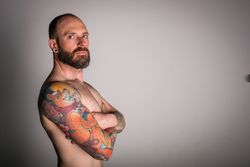 Young bearded guy with tattoos on hand