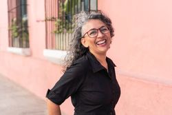 Latina woman with graying hair posing outside