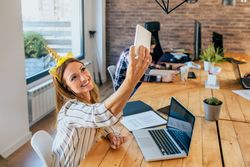 Business woman taking selfie with unicorn headband