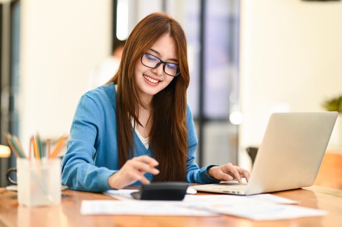 Woman with glasses working happily at home