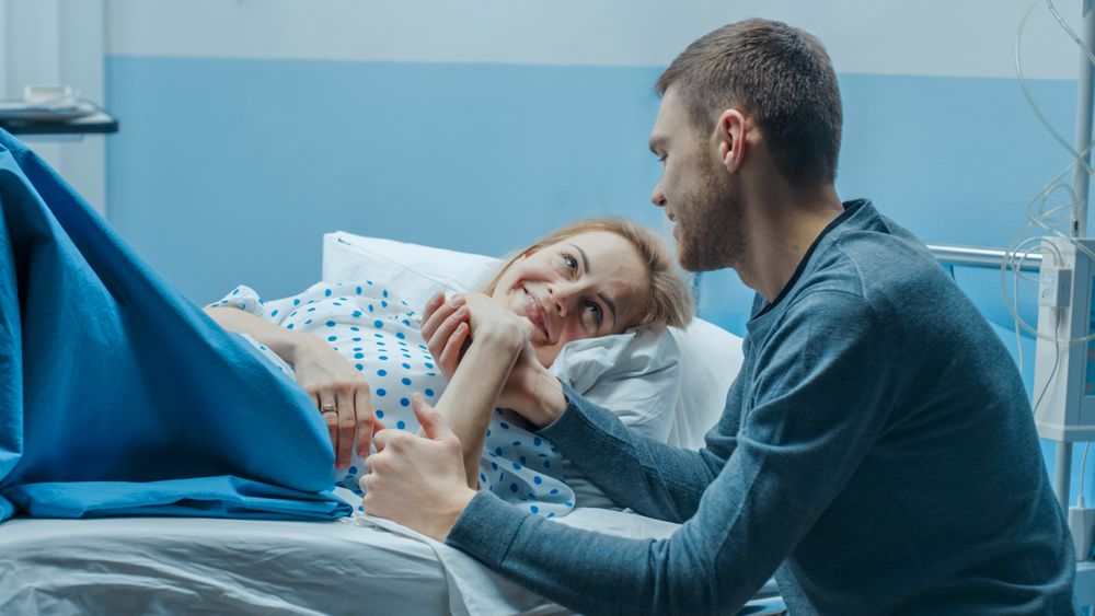 In the Hospital Supportive Father Talking With His Wife after Childbirth