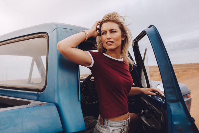 Woman standing besides her car and looking back