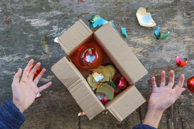 A woman received a parcel with broken Christmas tree glass balls. The concept of a bad packing of goods.