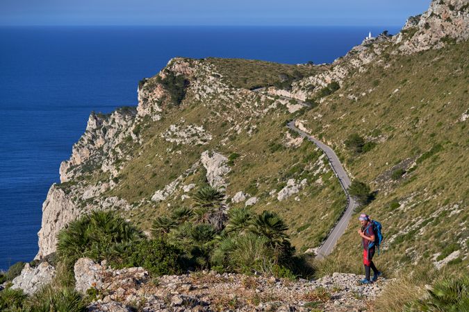 Traveler walking along rocky cliff