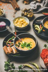 Yellow lentil soup bowl, bread, vegetable garnishes, selective focus, vertical composition bEEKMb