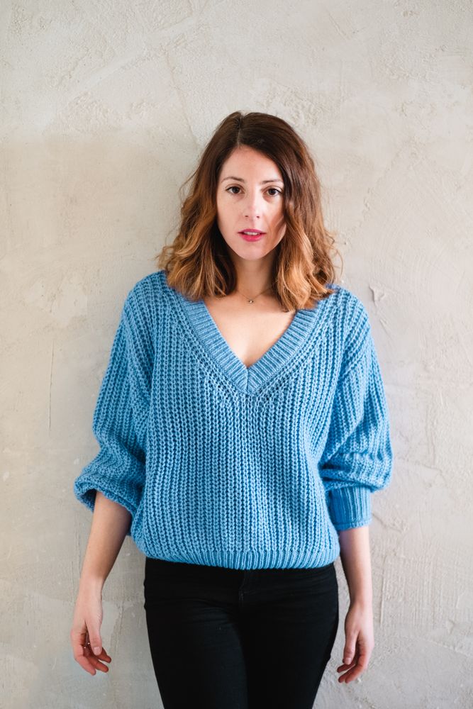 Charming woman in sweater near wall