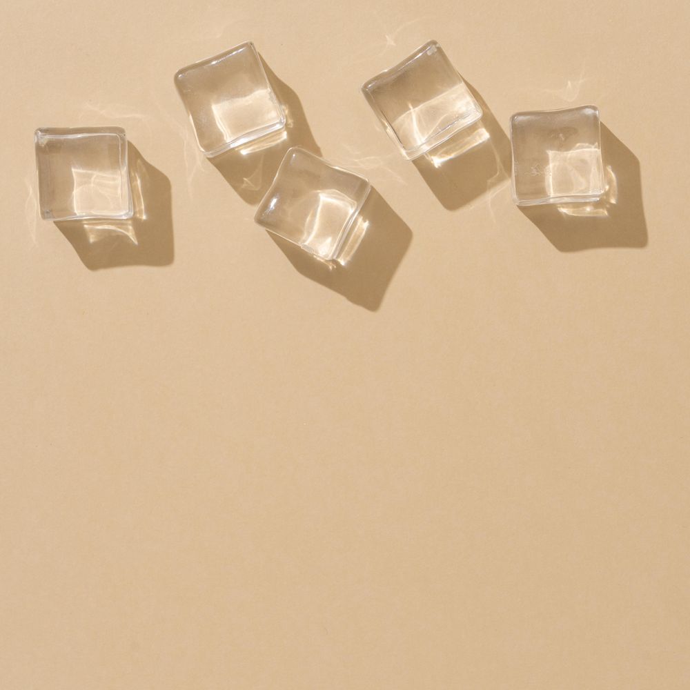 Flat lay of ice cubes on beige background with shadows
