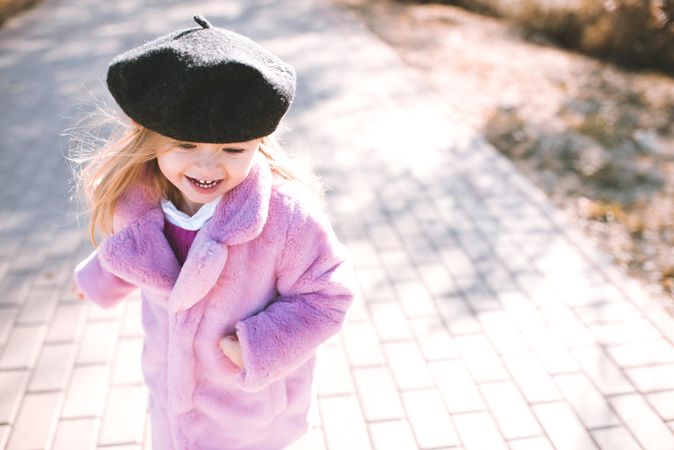 Smiling girl in fluffy autumn coat standing outdoor