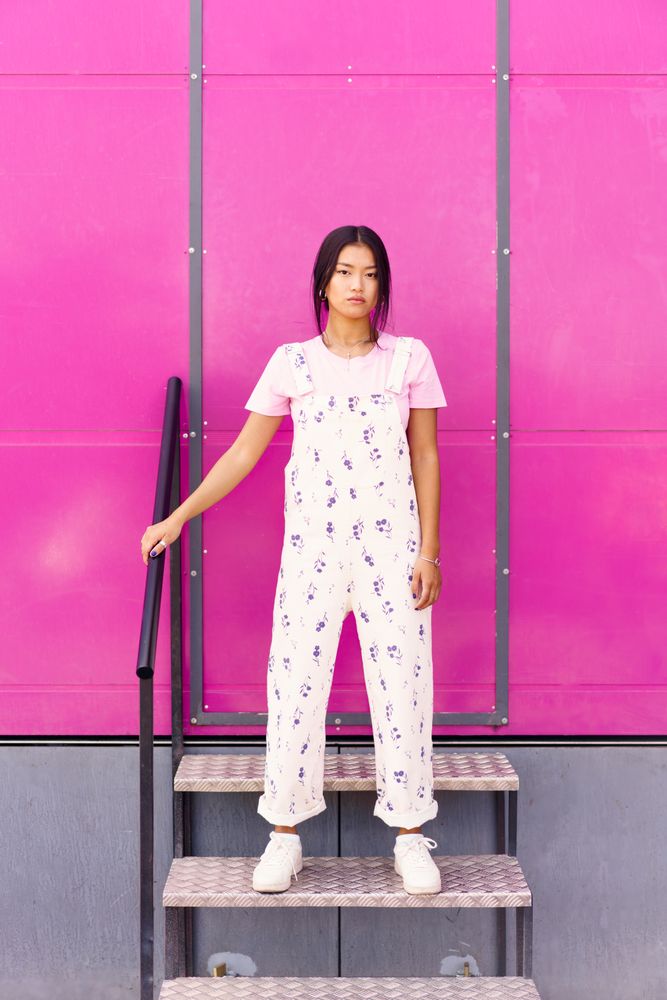 Chinese woman standing on stairs in front of pink trailer