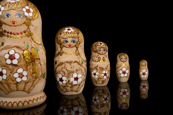 Wooden Russia matrioshka dolls in a row on a dark studio background