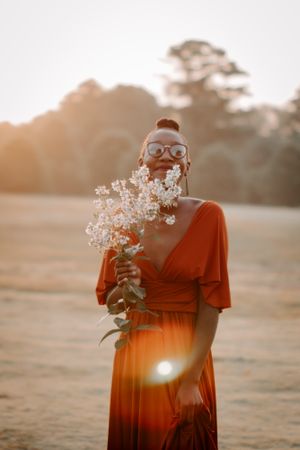 Woman holding light flowers in a grassy field