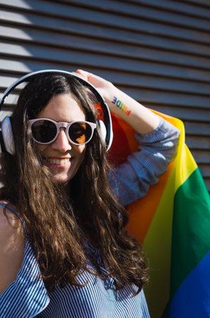 Woman posing happily with the LGBT flag