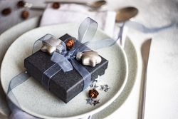 Festive Christmas card concept with blue gift box on grey background with copy space