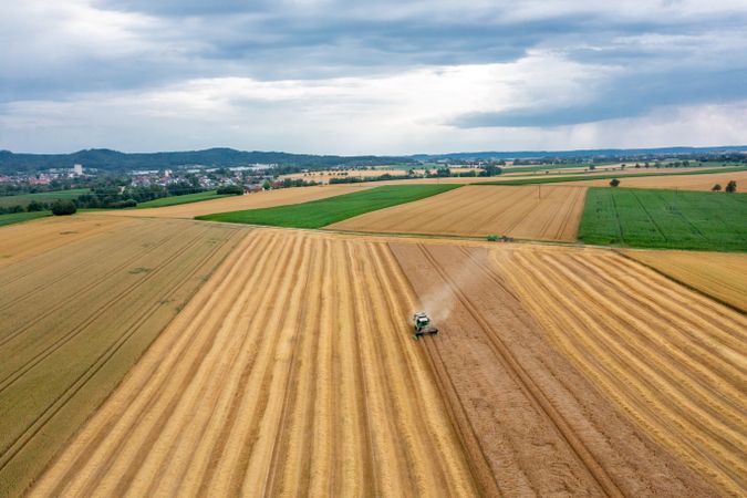 Drone aerial view of a combine harvesting wheat in Germany in the evening
