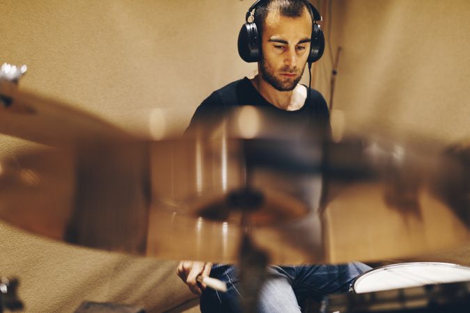 Man with headphones playing on drums