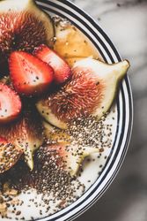 Flat-lay of yogurt bowl with fruit, close up