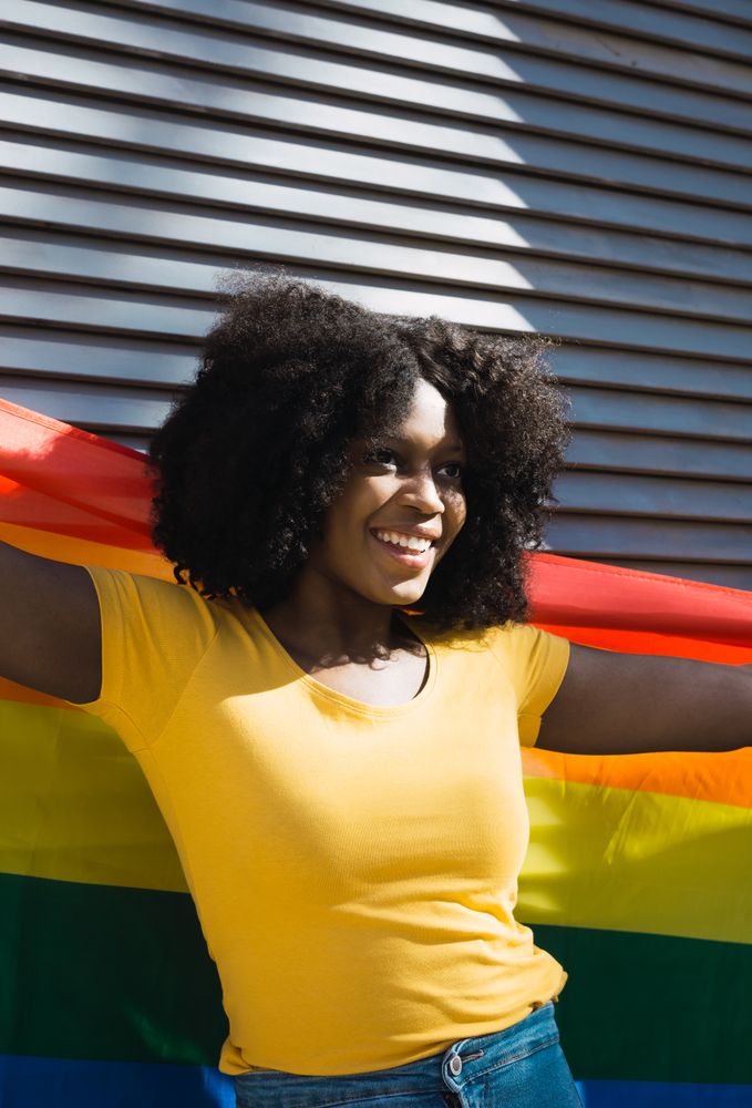 Woman posing happily with the LGBT flag