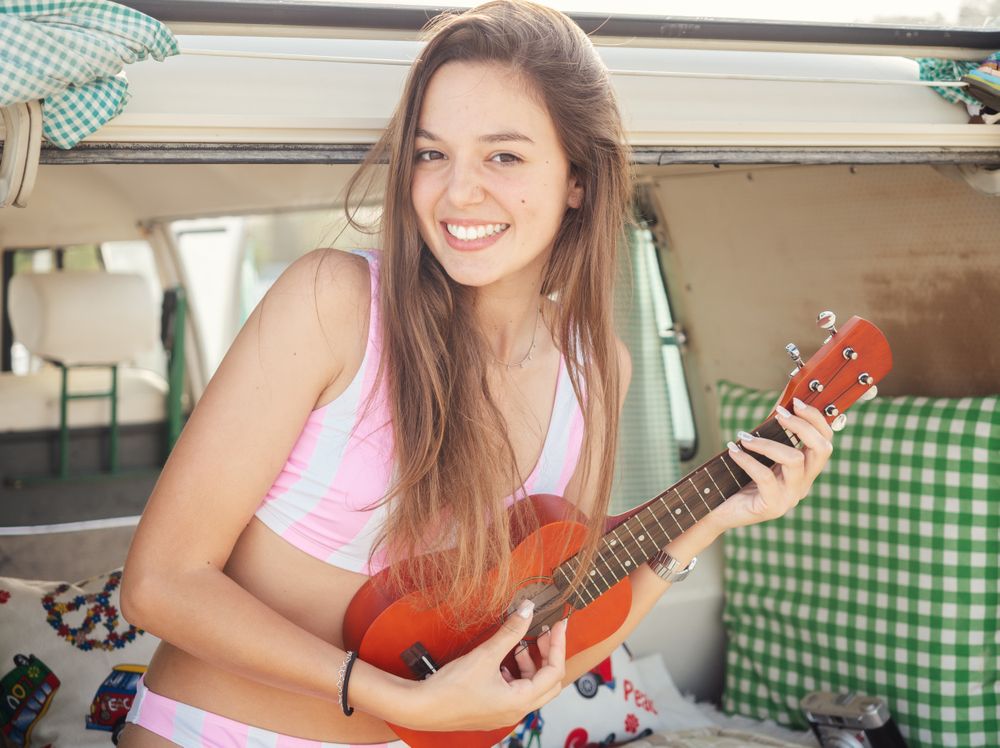 Woman playing ukulele sitting in trailer tank