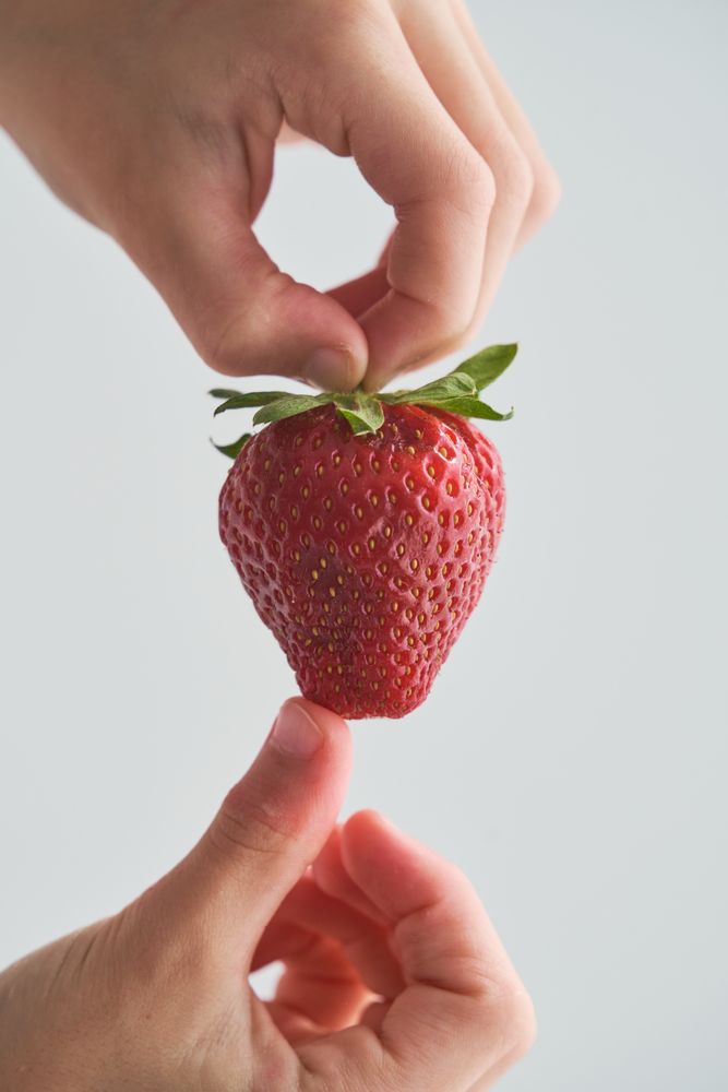 Anonymous person holding appetizing strawberry