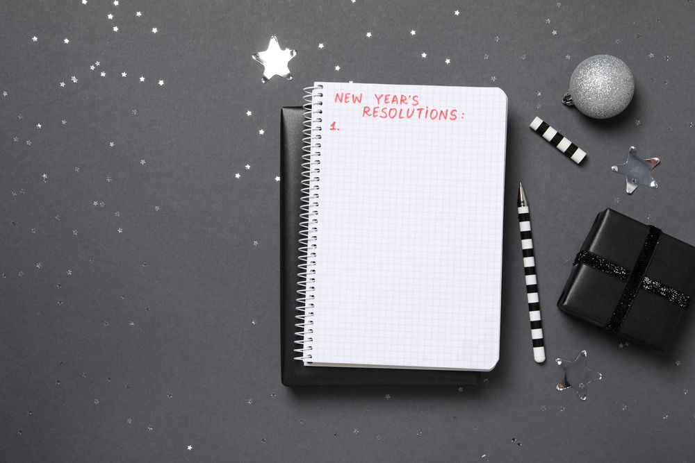 Gift boxes and notepad with list on gray background, space for text