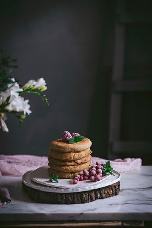 Pile of raspberry pancakes with honey on plate