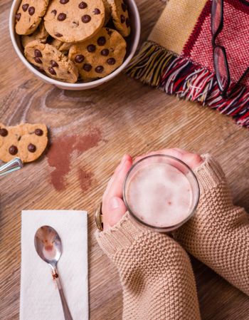 Female hands with hot drink and chocolate cookies