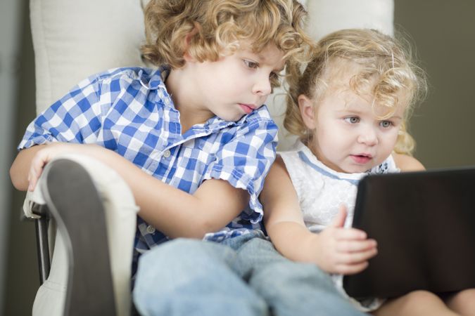 Young Brother and Sister Using Their Computer Laptop Together