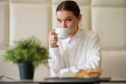 Woman sipping coffee in modern cafe