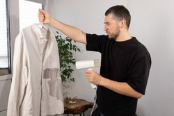 Man Steaming Shirt With Handheld Steamer