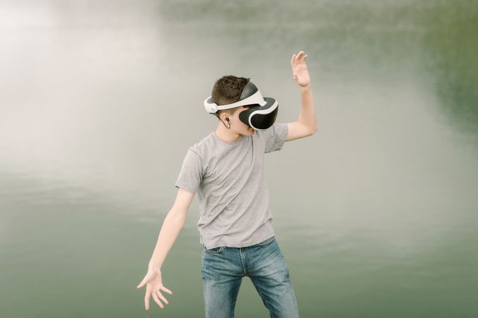 Young teenager with virtual reality glasses outdoors